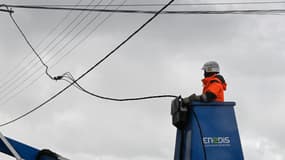 Un employé d'Enedis travaille sur des câbles électriques à Lanildut, dans le Finistère, le 2 novembre 2023, après le passage de la tempête Ciaran.