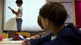 Un élève d'une classe parisienne dans une école publique, face à un tableau numérique interactif.