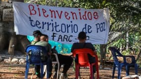 Des membres de la guérilla des Farc assis à l'entrée d'une zone où les rebelles doivent se rassembler pour déposer leurs armes, le 28 février 2017 à San José de Oriente, en Colombie