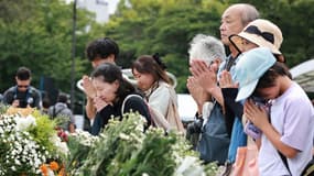 Des personnes se recueillant devant le cénotaphe commémoratif pour les victimes de la bombe atomique à Hiroshima (Japon), le 6 août 2025.