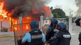 Des gendarmes postés devant la gendarmerie incendiée par des manifestants au Carbet, dans le nord de la Martinique.