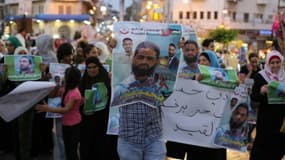 Des manifestants brandissent des affiches avec le portrait de l'avocat Mohammed Allan lors d'une manifestation de soutien, le 19 août 2015 à Ramallah, en Cisjordanie.