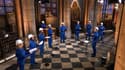 Huit chanteurs du chœur de la cathédrale Notre-Dame, en combinaison de chantier