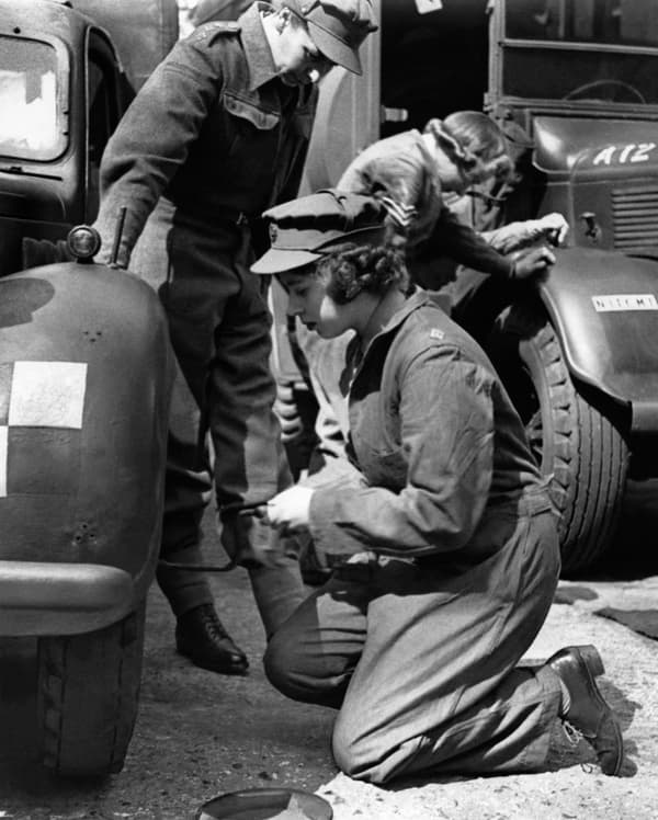 The future Queen Elizabeth II, then a princess, changing a wheel at a mechanics training center in southern England in 1945.