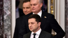 Le président ukrainien Volodymyr Zelensky devant ses homologues lituanien Gitanas Nauseda et polonais Andrzej Duda arrivant à une conférence de presse à Kiev le 23 février 2022
