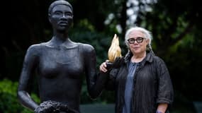 L'artiste plasticienne américaine Alison Saar pose à côté de la sculpture faite pour les Jeux olympiques et paralympiques de Paris 2024 dans le jardin Charles-Aznavour au pied des Champs-Élysées à Paris, le 21 juin 2024.