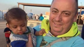 L'humanitaire britannique Alan Henning, ici portant un enfant syrien réfugié dans ses bras, est menacé de mort par Daesh. 