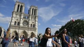 Des touristes devant Notre-Dame de Paris