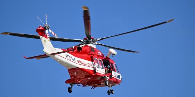 Un hélicoptère des pompiers italiens au-dessus de Porticello, dans le cadre des recherches des personnes disparues dans le naufrage d'un yacht en Sicile, le 23 août 2024