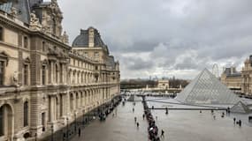 Des visiteurs font la queue, près de la pyramide conçue par l'architecte sino-américain Ieoh Ming Pei, pour entrer au musée du Louvre, le 19 novembre 2025 à Paris