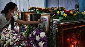 Une femme se recueillant sur le portrait d'un petit garçon tué jeudi à Nong Bua Lamphu, en Thaïlande, le 8 octobre 2022