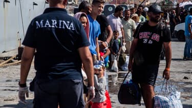 Des migrants sur l'île de Lampedusa en Italie attendant d'être transférés en Sicile, le 15 septembre 2023.