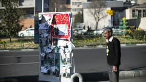 Un homme se tient à côté d'affiches électorales à Téhéran, capitale de l'Iran, le 25 février 2016
