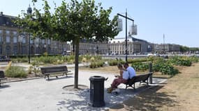 Un couple assis à l'ombre à Bordeaux le 23 juillet 2019. 