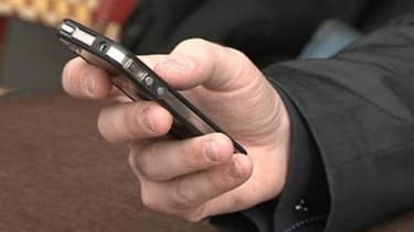 Un homme utilise son téléphone mobile.