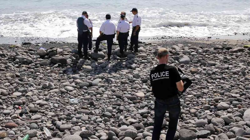 Des inspecteurs de police examinent des débris sur la plage de Saint-Denis, à la Réunion