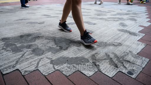 Des habitants de Hong Kong foulent le 2 juin 2020 un trottoir dont les pavés ont été remplacés par du béton par les autorités locales, en réponse aux manifestations pro-démocratie.