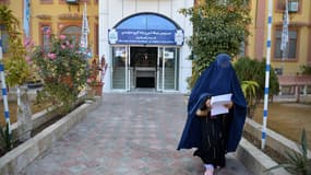 Une femme marche devant une université afghane dans la province de Kandahar, le 21 décembre 2022