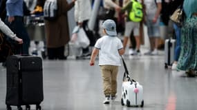 Un enfant tire sa valise dans le hall d'embarquement de l'aéroport de Düsseldorf, le 2 juillet 2021 en Allemagne - Illustration - Archives AFP