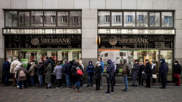 Des personnes font la queue devant une succursale de la banque publique russe Sberbank, à Prague le 25 février 2022, pour y retirer leurs avoirs
