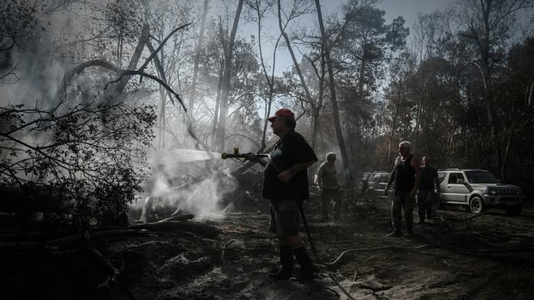 Michel Boigné, membre de la Défense des forêts contre les incendies (DFCI), arrose une reprise de feu, le 9 août 2022 près de La Teste-de-Buch, en Gironde