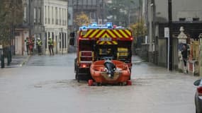 Un camion de pompiers tire un dinghy dans une rue inondée d'Isques, près de Boulogne-sur-mer, le 10 novembre 2023 dans le Pas-de-Calais.