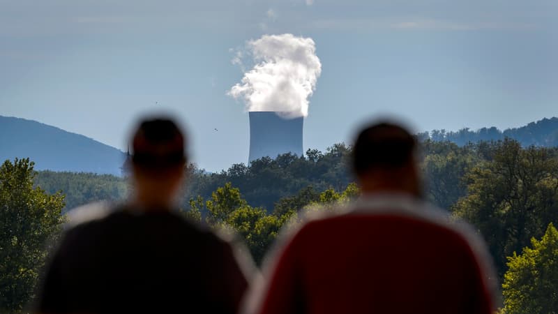 Deux homme font face à la tour de refroidissement de la centrale nucléaire de Goesgen de la ville suisse d'Aarau.