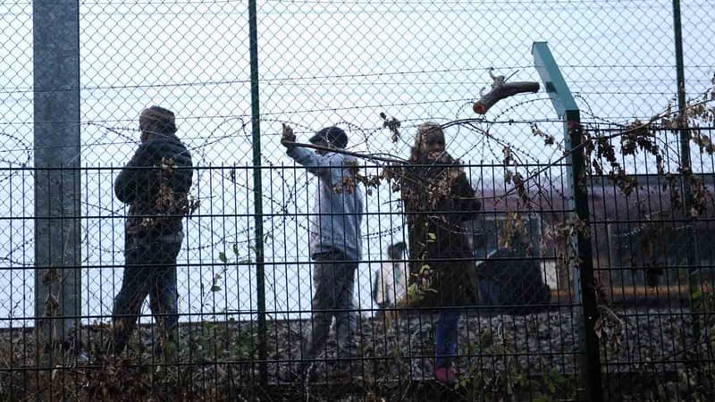 Des migrants marchent le long des rails sur le site de Calais-Frethun
