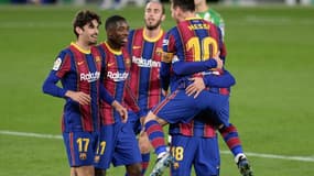 L'attaquant argentin du FC Barcelone, Lionel Messi, félicité par ses coéquipiers, après avoir égalisé contre le Bétis Séville, lors de leur match en Liga, le 7 février 2021 à Séville