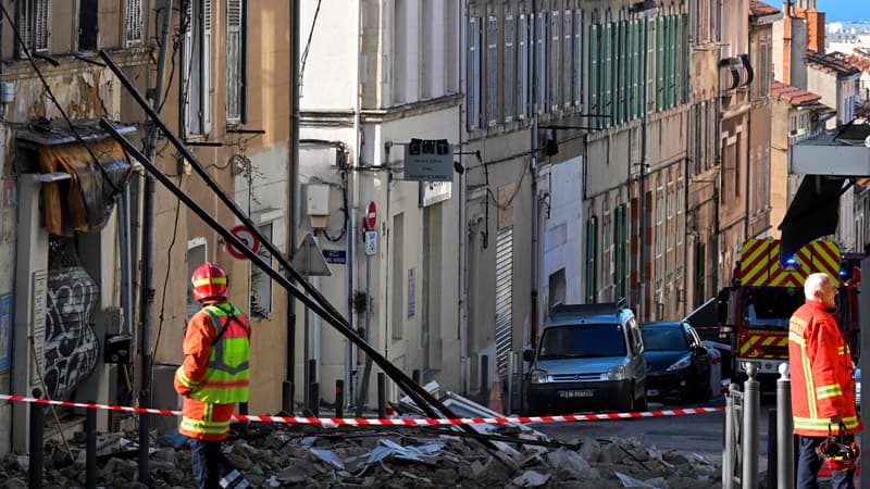 Des pompiers se tiennent à côté d'un bâtiment partiellement détruit, après qu'un incendie s'est déclaré dans la nuit, à Marseille, dans le sud de la France, le 3 décembre 2023.