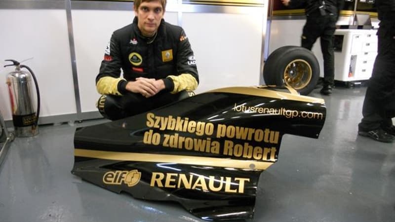 Vitaly Petrov pose devant l'aileron qui rend hommage à Robert Kubica