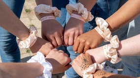 Les poignets de participantes à un enterrement de vie de jeune fille, affublés de bracelets et de chouchous assortis.