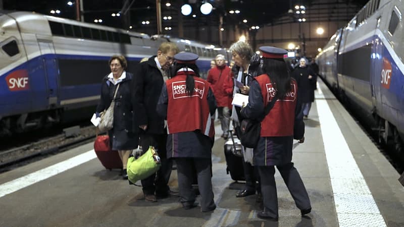 Des agents SNCF attendent à l'arrivée d'un train pour donner aux passagers des formulaires de remboursement. 