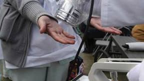 Examen de victimes potentielles de radiations à Nihonmatsu, dans la préfecture de Fukushima. Les autorités japonaises s'employaient dimanche à éviter la fusion du coeur de trois réacteurs nucléaires de la centrale de Fukushima Daiichi, endommagée par le s