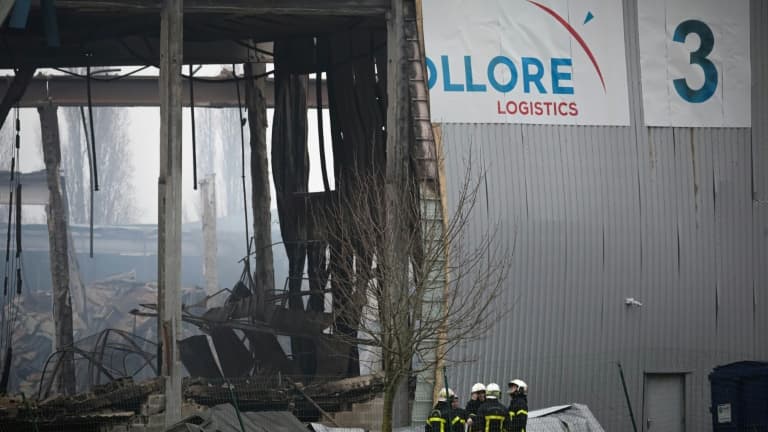 Des pompiers devant un bâtiment industriel loué par Bolloré Logistics endommagé par un incendie, le 17 janvier 2022 à Grand-Couronne, au sud de Rouen.