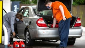 Des automobilistes remplissent des bidons d'essence, le 12 mai 2021 à Charlotte, en Caroline du Nord (Photo d'illustration)