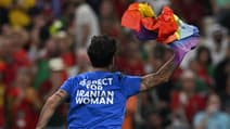 Un supporter avec un drapeau LGBT+ et un message pour les femmes iraniennes lors de Portugal-Uruguay