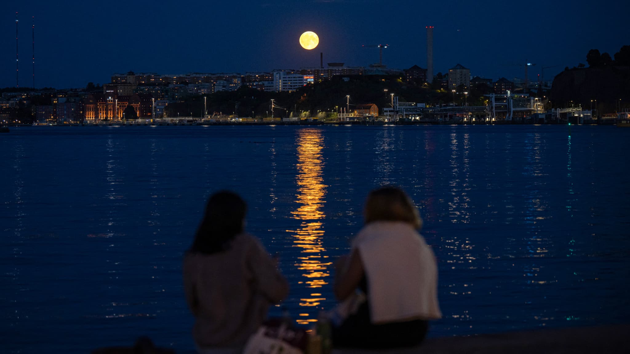 Les gens regardent la Super Lune Bleue se lever derrière Nacka, à Stockholm, le 19 août 2024.