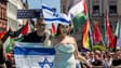 Yuval Raphael représentant Israël marche sur le tapis turquoise à Bâle avec des drapeaux palestiniens derrière lors de la cérémonie d'ouverture du Concours Eurovision de la chanson 2025 à Bâle le 11 mai 2025.