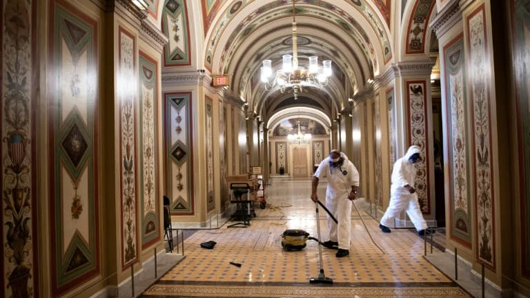 Des employés du Congrès nettoient les couloirs du Capitole le 7 janvier 2021 à Washington, au lendemain de l'attaque de partisans du président Donald Trump