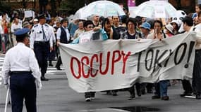 Les "indignés" manifestent ce samedi à travers la planète (comme ici à Tokyo) pour dénoncer le poids de la finance et les politiques d'austérité qui, disent-ils, mènent le monde à la ruine et condamnent une partie de l'humanité à la pauvreté. Des rassembl