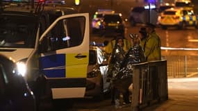 Des spectateurs près d'une salle de concerts à Manchester le 23 mai 2017, où une possible attaque terroriste a fait 19 morts et une cinquantaine de blessés