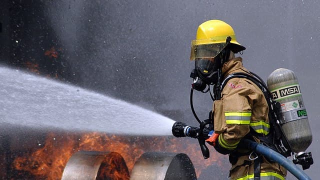 Un pompier tente d'éteindre un incendie (image d'illustration)