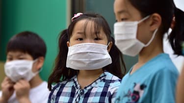Des enfants portent des masques de protection lors d'un cours de prévention contre le coronavirus MERS, le 2 juin, à Séoul, en Corée du Sud.