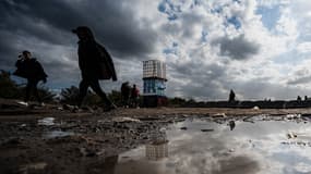 Des migrants marchent au camp de Loon-Plage, le 11 octobre 2022.