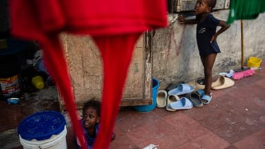 Des enfants jouent devant le Rex Theatre, transformé en refuge pour les personnes déplacées, dans le centre-ville de Port-au-Prince, en Haïti, le 17 juillet 2025. 