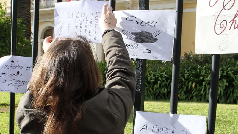 Une élève accrochant un message de soutien à la grille de la préfecture d' Ajaccio en Corse, le 8 janvier 