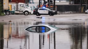 Une voiture est partiellement submergée sur une route inondée lors d'une tempête de pluie à Long Beach, Californie, le 1er février 2024. 