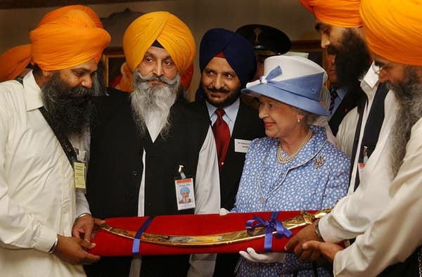 La reine Elizabeth II recevant en 2002 un sabre cérémonial de la communauté Sikh de Leicester en Grande Bretagne.
