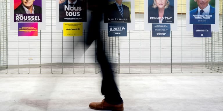 Des électeurs passent devant les affiches de candidats à l'élection présidentielle française, à Washington, le 9 avril 2022 